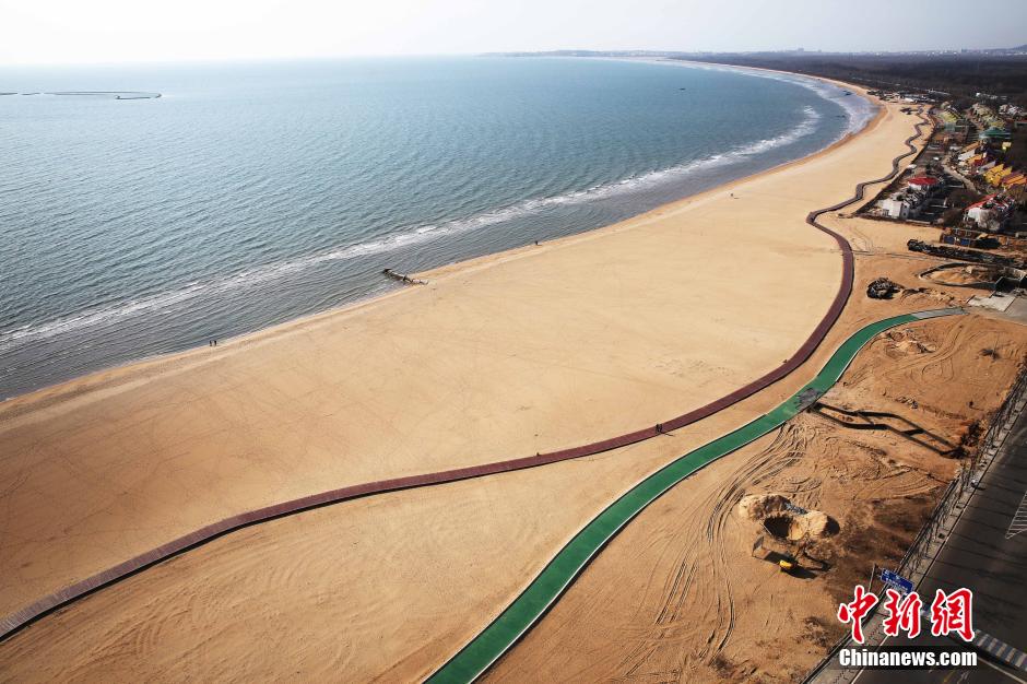 3月13日，秦皇島萬(wàn)米臨海沙灘木棧道。據(jù)了解，該木棧道全長(zhǎng)約4200米，與北戴河區(qū)原有的7500米木棧道對(duì)接后全線總長(zhǎng)度1.17萬(wàn)米，整個(gè)木棧道東起秦皇島體育基地游船碼頭，西至北戴河濕地公園，呈波浪形蜿蜒10.4公里海岸線。 中新社發(fā) 曹建雄 攝 CNSPHOTO