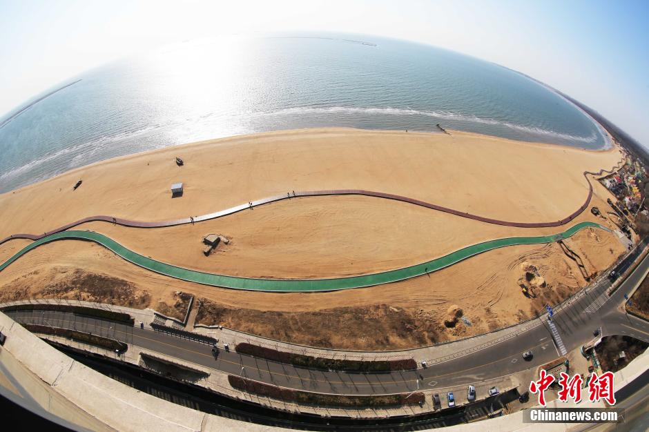 3月13日，秦皇島萬(wàn)米臨海沙灘木棧道。據(jù)了解，該木棧道全長(zhǎng)約4200米，與北戴河區(qū)原有的7500米木棧道對(duì)接后全線總長(zhǎng)度1.17萬(wàn)米，整個(gè)木棧道東起秦皇島體育基地游船碼頭，西至北戴河濕地公園，呈波浪形蜿蜒10.4公里海岸線。 中新社發(fā) 曹建雄 攝 CNSPHOTO